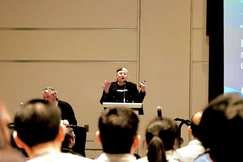 Dr Danni Smith giving presentation at lectern  on IonOpticks columns.