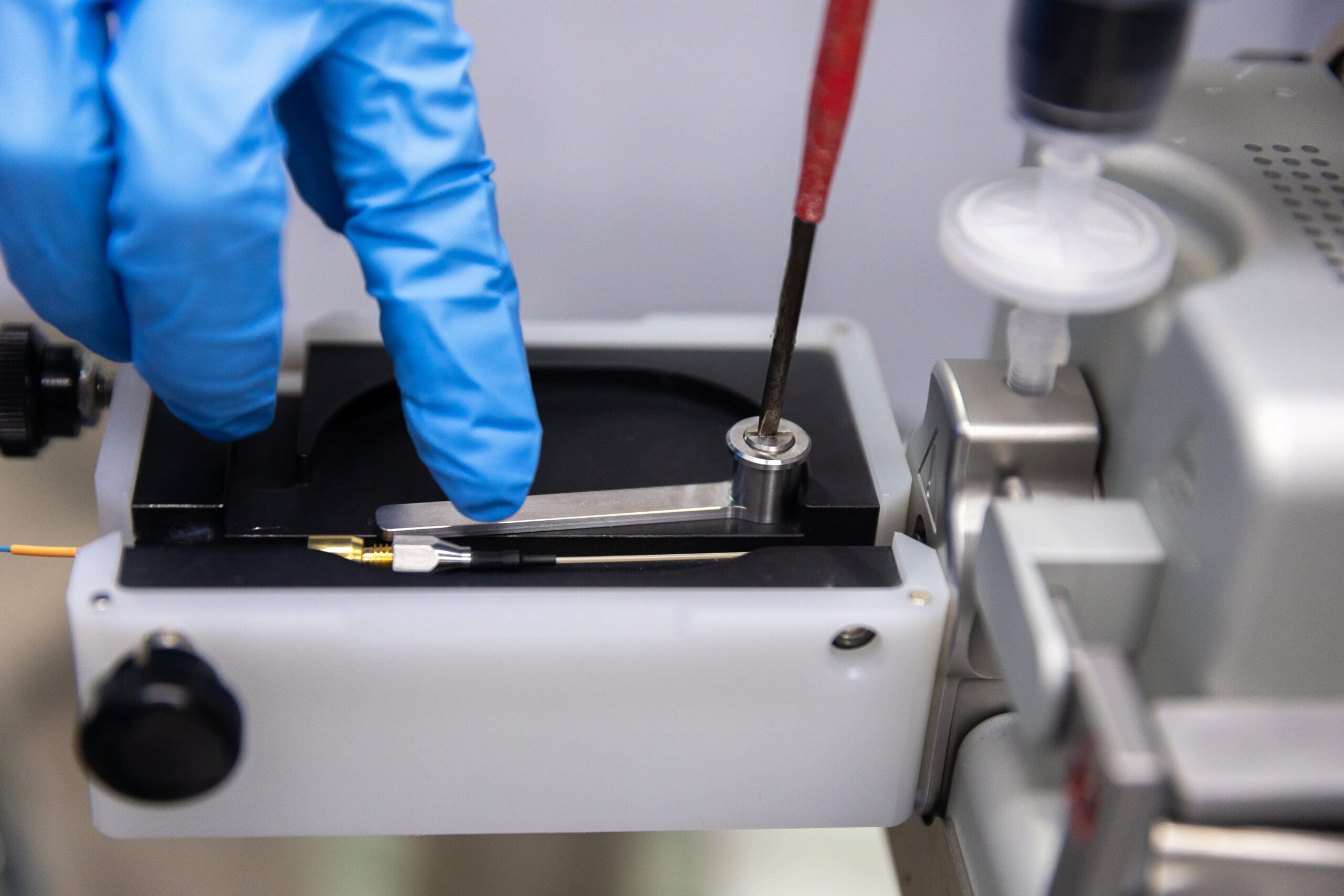 Blue gloves installing IonOpticks Aurora Rapid® (55mm) Grounding arm