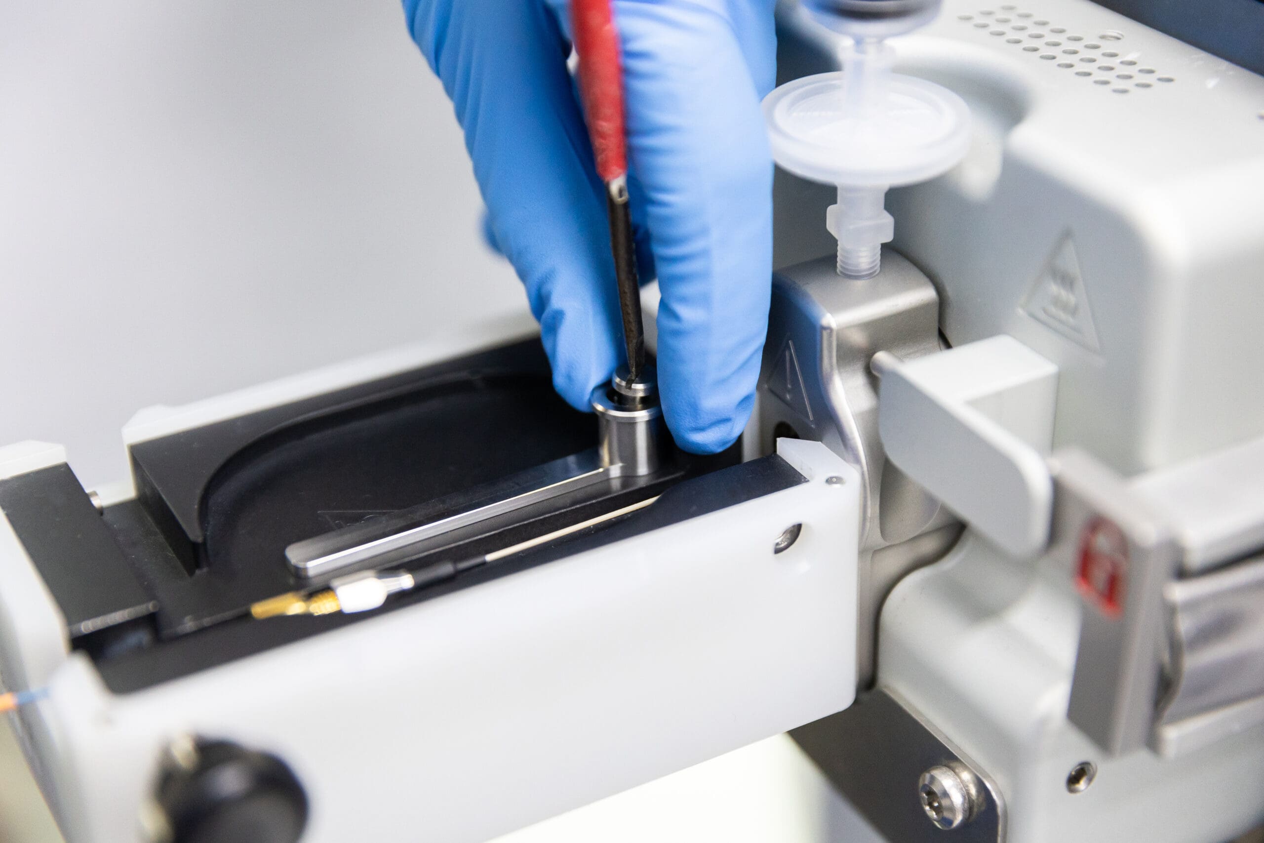 Blue gloves installing IonOpticks Aurora Rapid® (55mm) Grounding arm