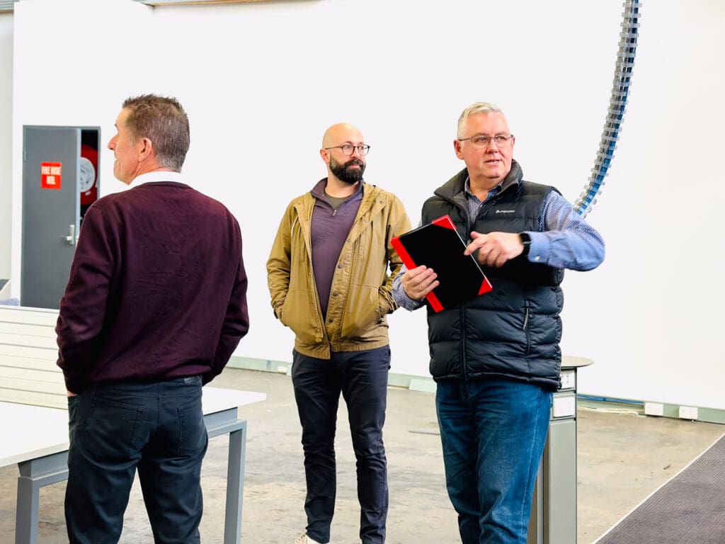 Three people standing around talking on a construction site as IonOpticks builds new facility in Melbourne. From left to right, David Murphy, Xavier Perronnet and David Sinden.